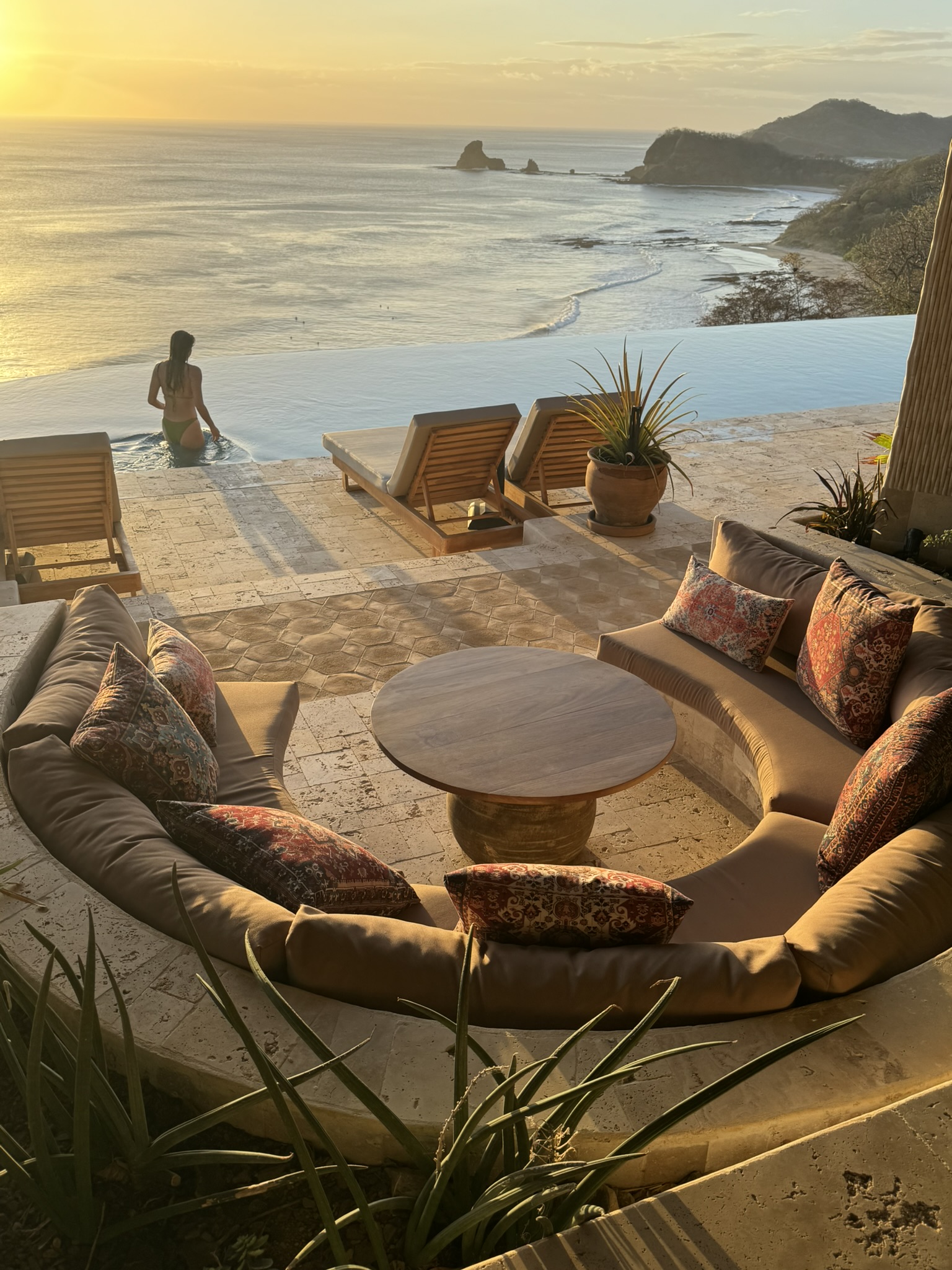 Sunken lounge and infinity pool overlooking the Pacific coast at sunset