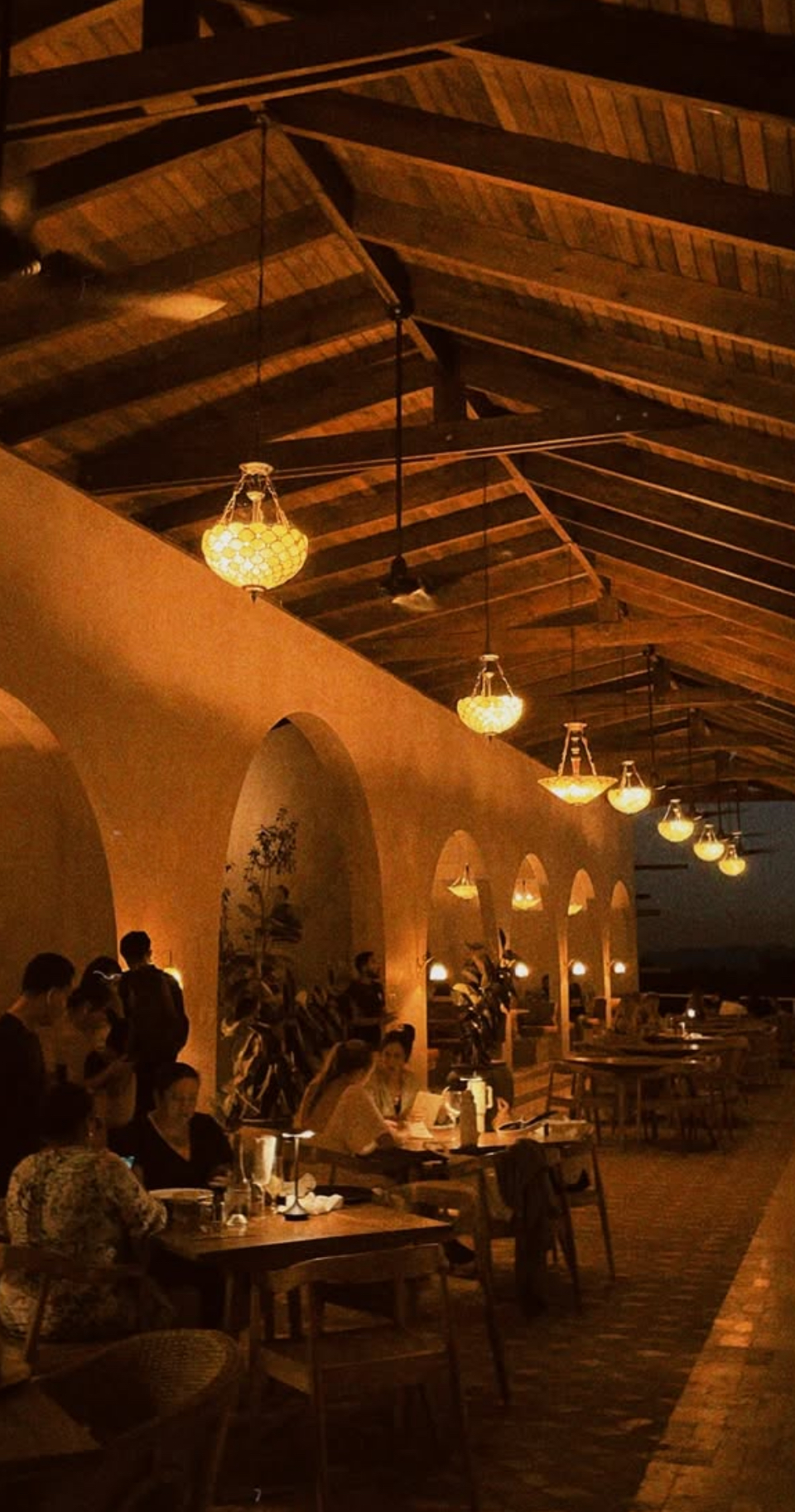 Nighttime restaurant interior with hanging lanterns and arches