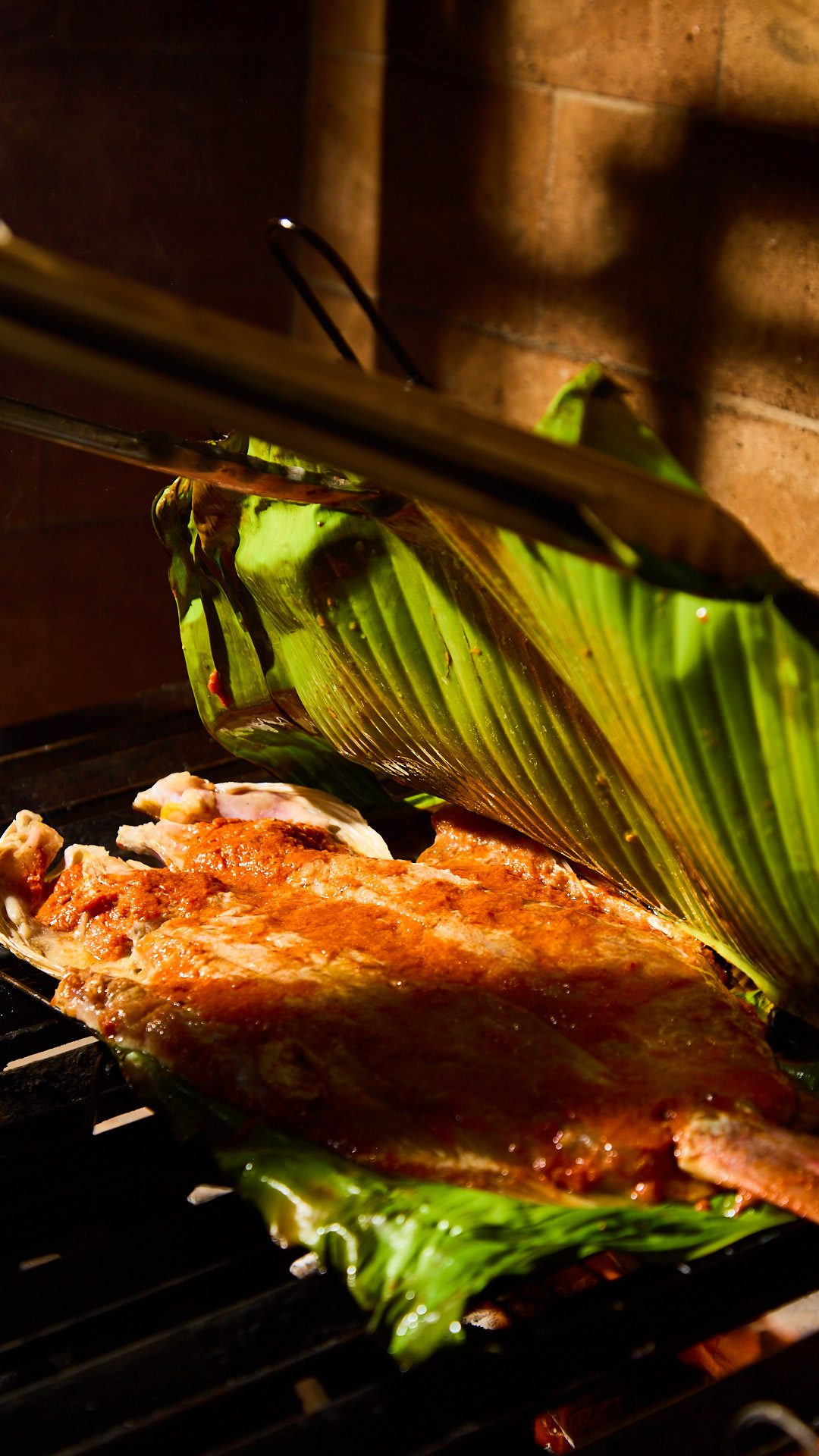 Fish grilled in banana leaf over wood fire