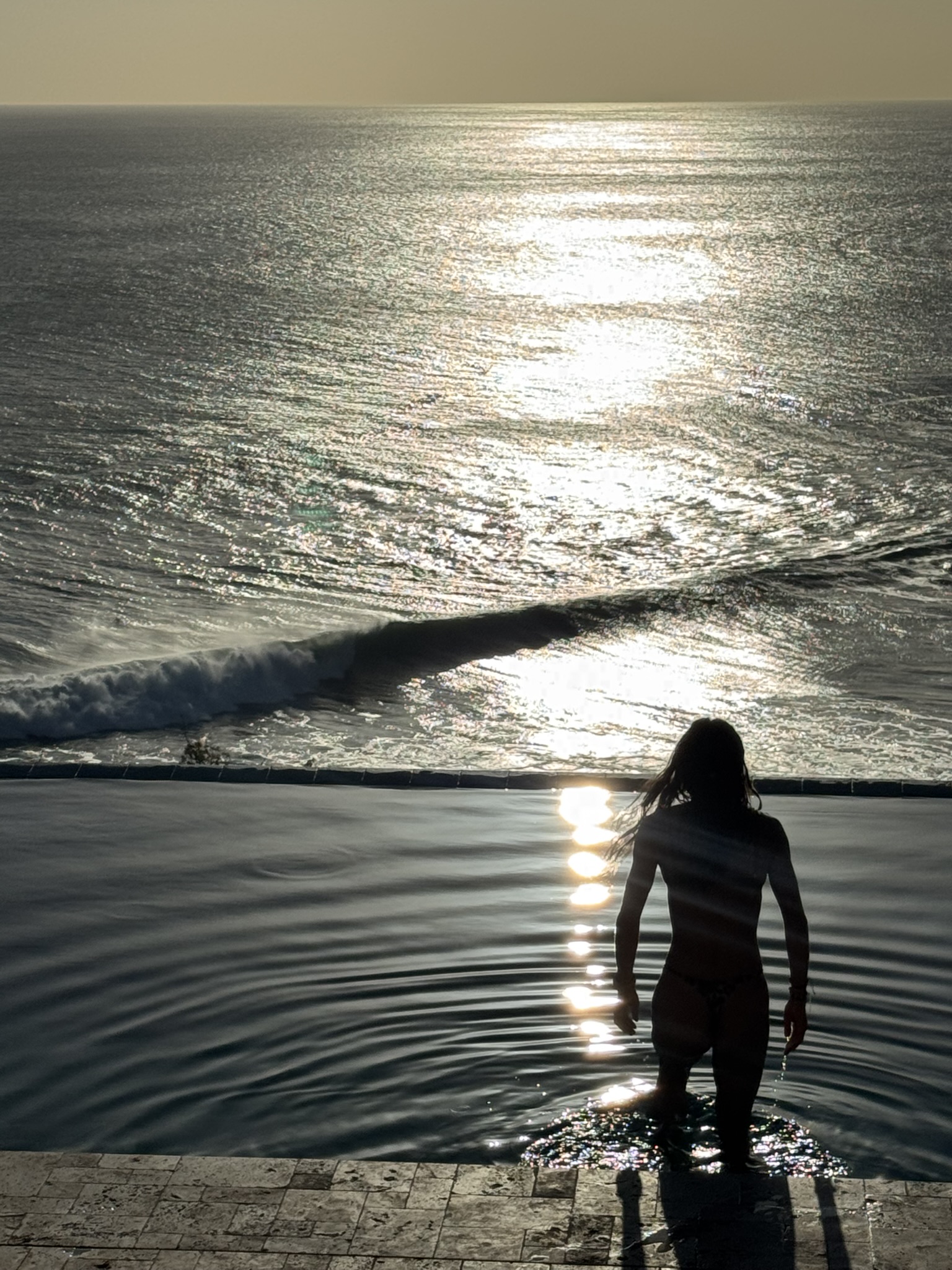 Silhouette in the infinity pool at sunset
